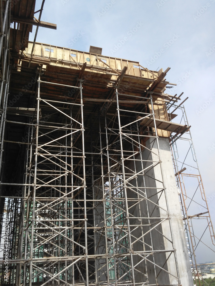 Metal scaffolding installed by construction workers at the construction site. It is used as temporary support structure and as the platform for workers to work on it. 