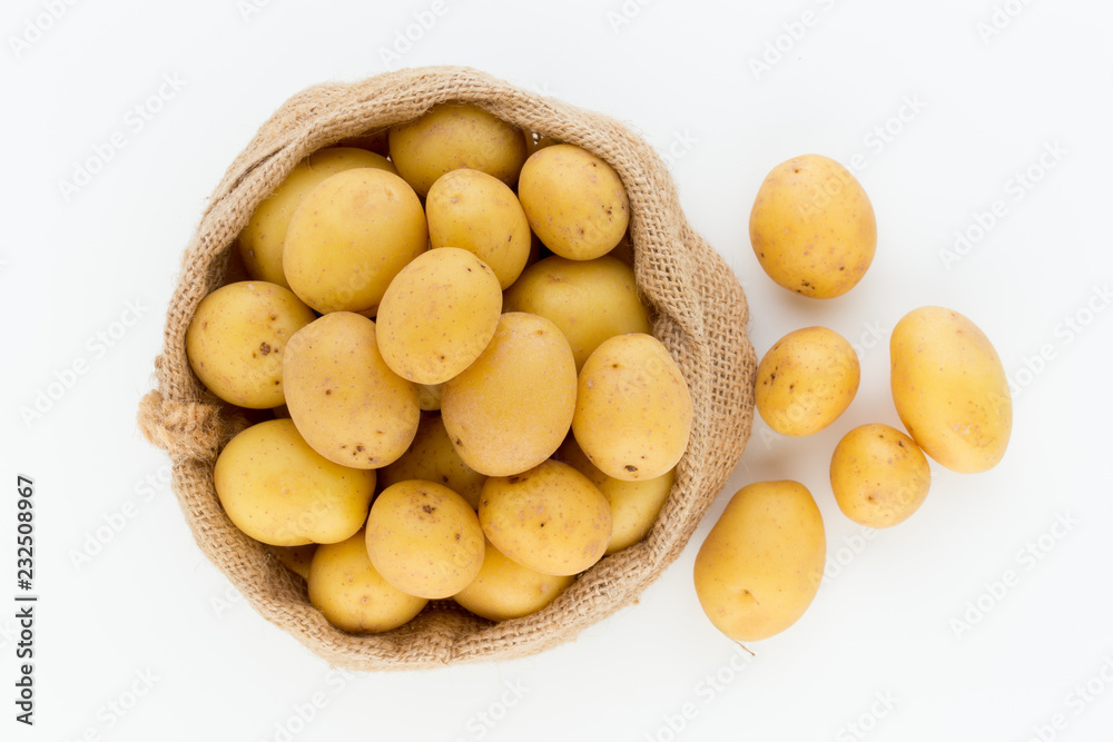 Sack of fresh raw potatoes on wooden background, top view Sack of fresh raw potatoes on wooden background, top view