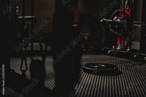 Weight plate on the floor in the gym with low light
