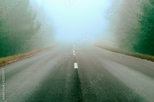 road markings and lines. Mist covers part of the road. traveling far for long distances. Highway in a natural landscape.