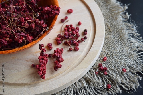 Useful Chinese lemongrass.Dried berry in a plate on a wooden background. photo