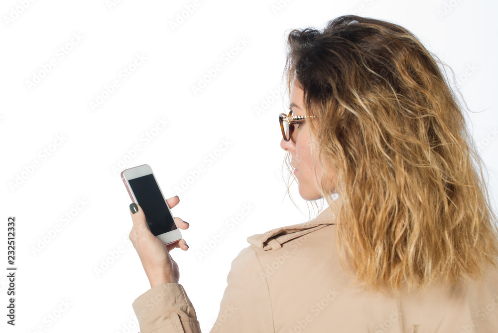 Businesswoman in autumn coat looking into the phone. isolated on white background. close up. Beautiful sexy brunette woman business office style fashion clothes Businesswoman in autumn coat looking into the phone. isolated on white background. close up. Beautiful sexy brunette woman business office style fashion clothes