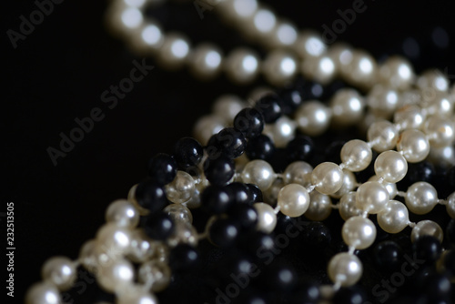 Black and white beads necklace on a dark background close up