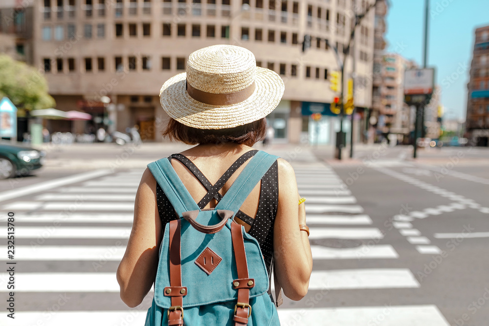 Young woman crossing a zebra pedestrian crosswalk