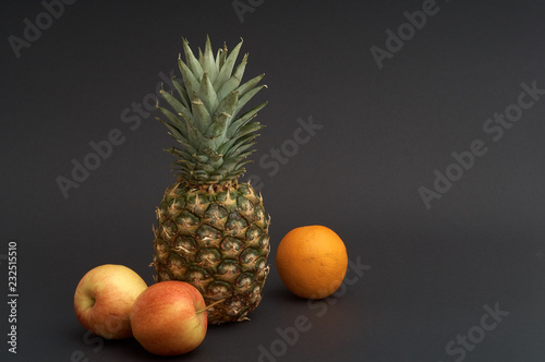 pineapple, apple, orange on black background