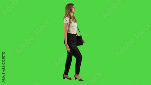 A young businesswoman walking and bumps into people, upset,  fast, full sideways shot, green screen.