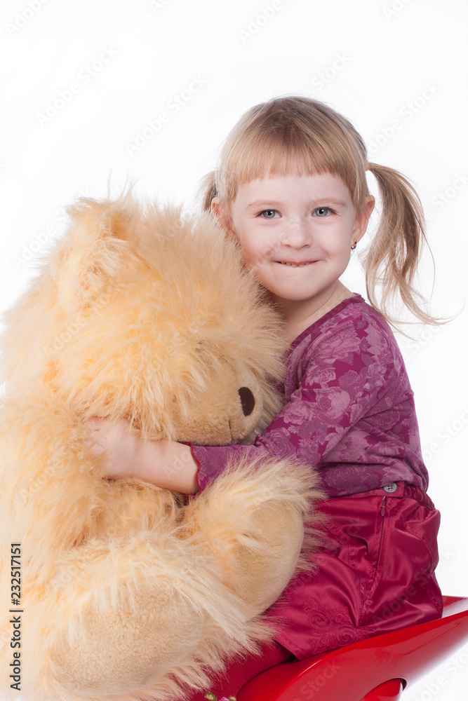 A sweet baby girl hugs her teddy and smiles A sweet baby girl hugs her teddy and smiles