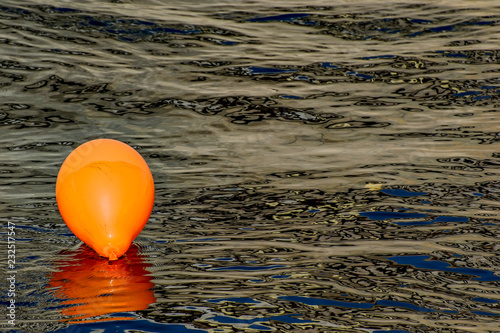 Orange balloon in the water of the river.