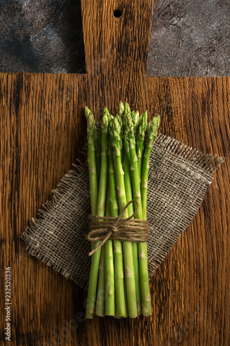 Fresh asparagus on a cutting board  rustic background. Top view  flat lay.