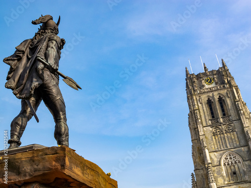 Rear view of the statue of Ambiorix in Tongeren, the oldest town in Belgium, the tower of Tongeren Basilica of Our Lady in the background