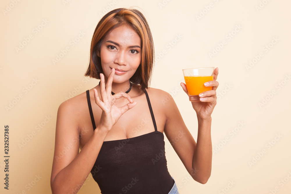 Young Asian woman show OK drink orange juice. Young Asian woman show OK drink orange juice.