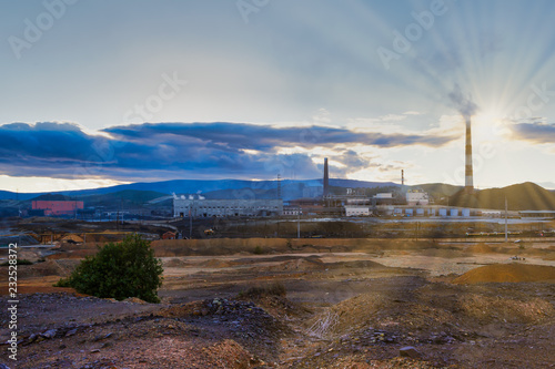 Environmental disaster. Copper plant in the valley against the background of the mountains, toxic smoke from the pipes,