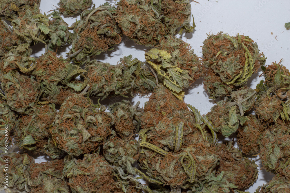 Close up of deep green and red haired marijuana buds in a large pile.
