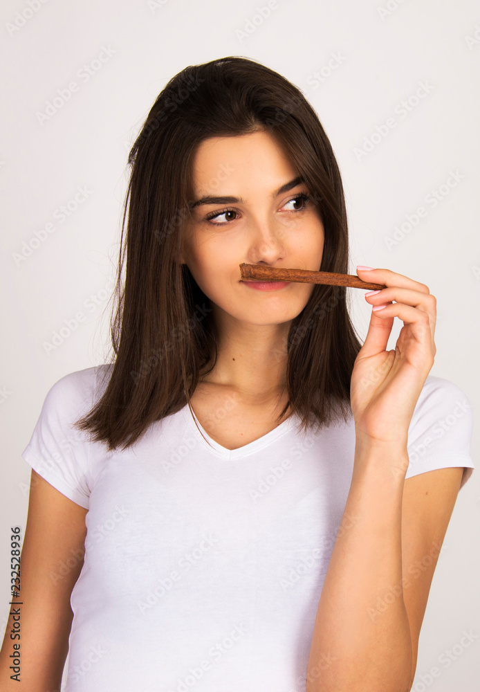 cinnamon concept girl holding and smelling cinnamon stick cinnamon concept girl holding and smelling cinnamon stick