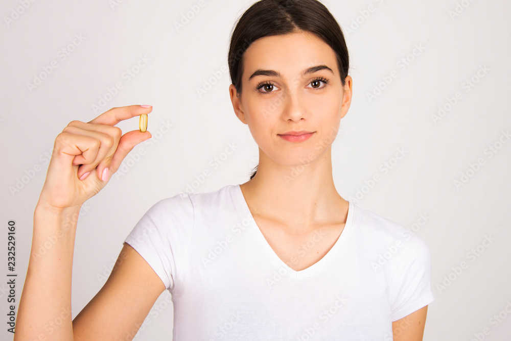 beautiful girl holding pill or capsule close up isolated beautiful girl holding pill or capsule close up isolated