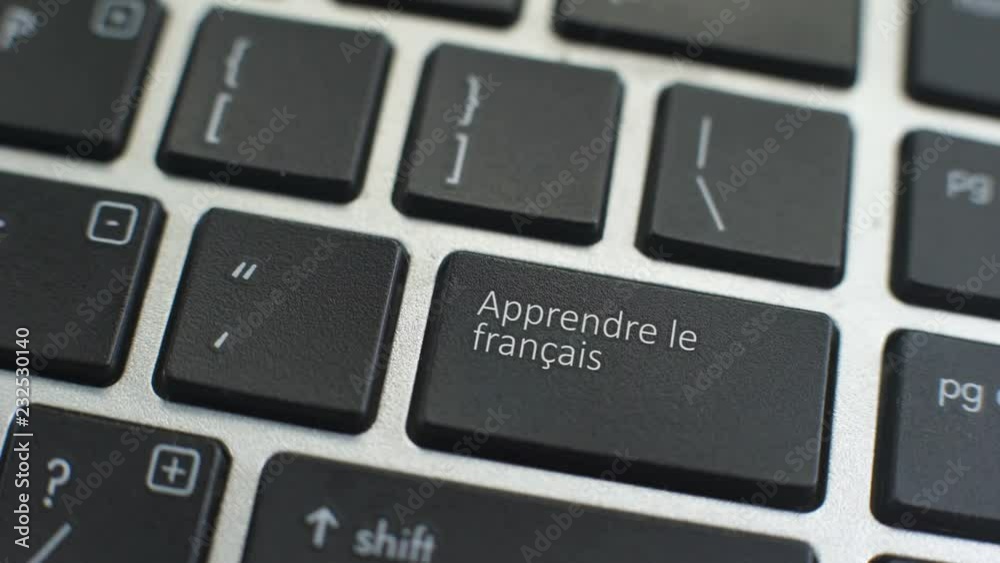 Learn French button on computer keyboard, female hand fingers press key Learn French button on computer keyboard, female hand fingers press key
