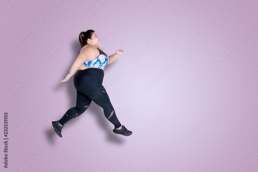 Overweight woman runs on studio
