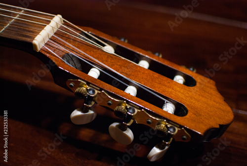 Close-up of the head of a guitar and it's strings