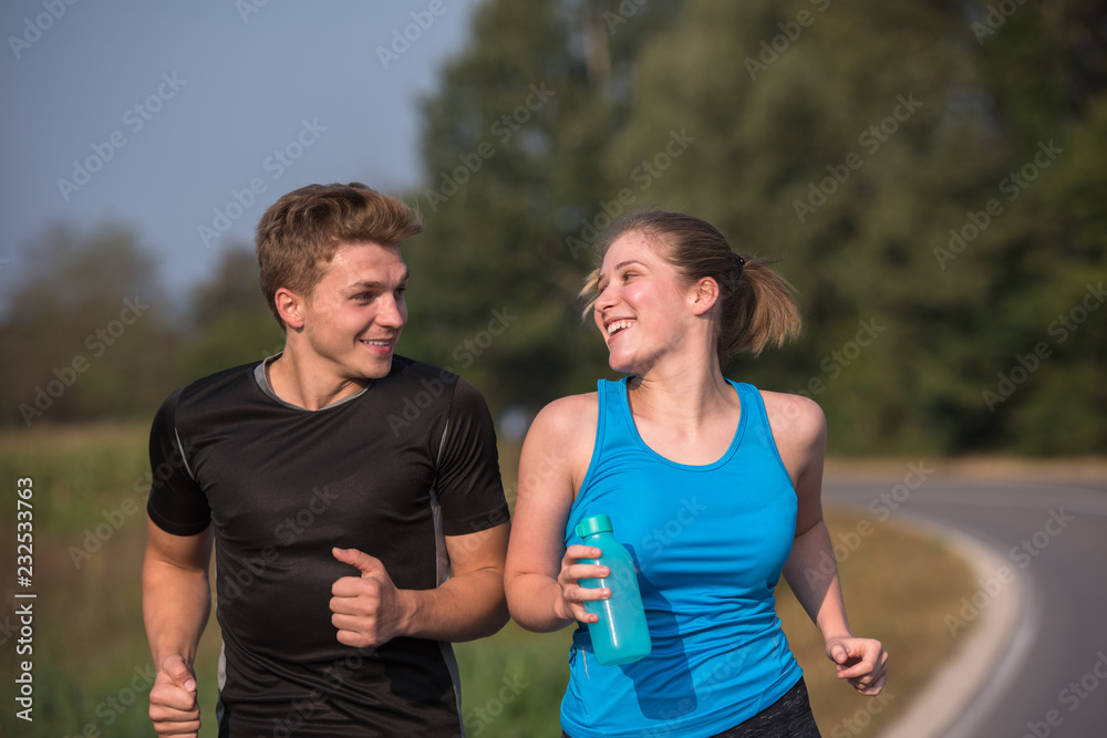 Obraz premium young couple jogging along a country road