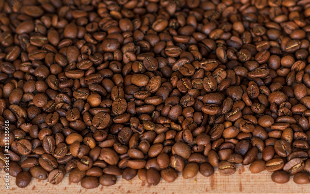 Closeup of fragrant roasted coffee beans on a wooden board. Selective focus. place for text. Closeup of fragrant roasted coffee beans on a wooden board. Selective focus. place for text.