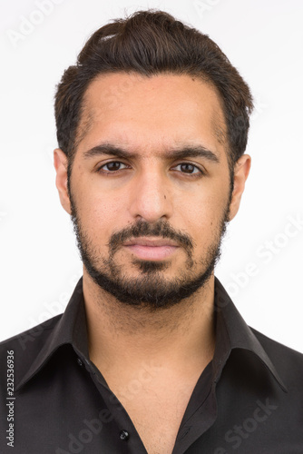 Face of young handsome Indian man looking at camera