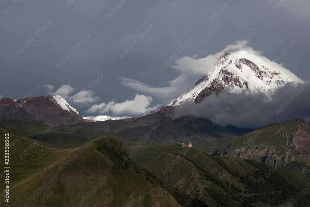 Fototapeta premium Beautiful panorama view on Kazbek peak mount from the Stepantsminda village in the summer
