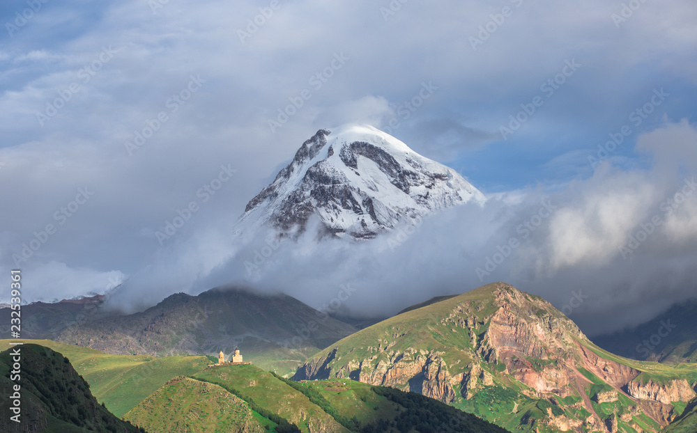 Beautiful panorama view on Kazbek peak mount from the Stepantsminda village in the summer