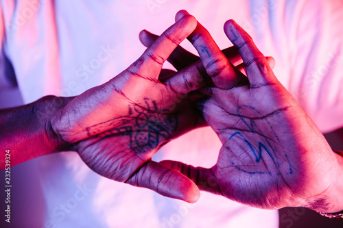 Mans tattooed palms showing a cruxifix photo