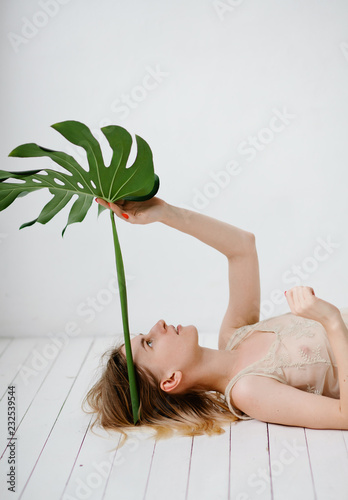 Dreaming model posing with huge leaf