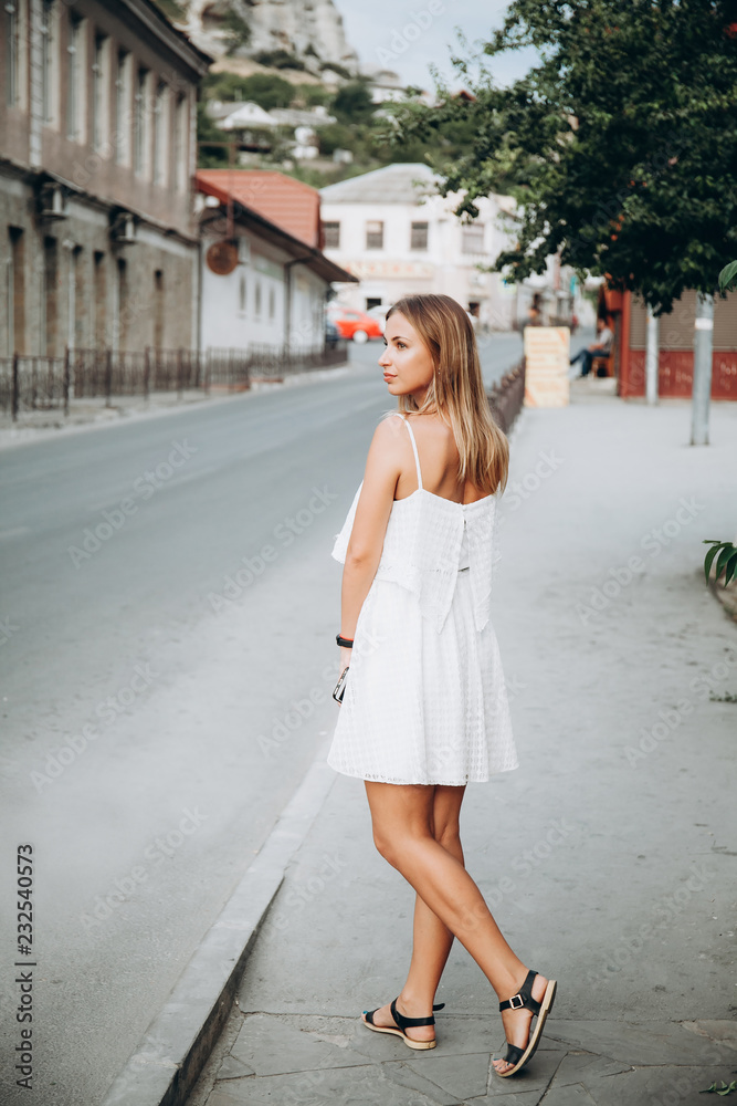 Woman in white dress walking at the street