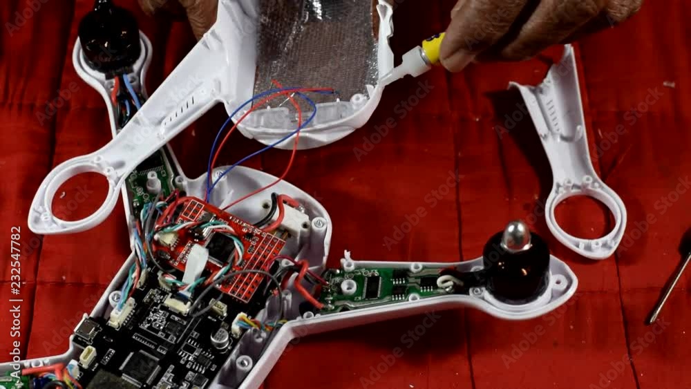 Inventive, resourceful Old man repairing broken quad-copter that he accidentally crash