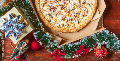 pizza in the Christmas decorations. Concept for promotions and bonuses when buying pizza for Christmas and New Year holidays photo