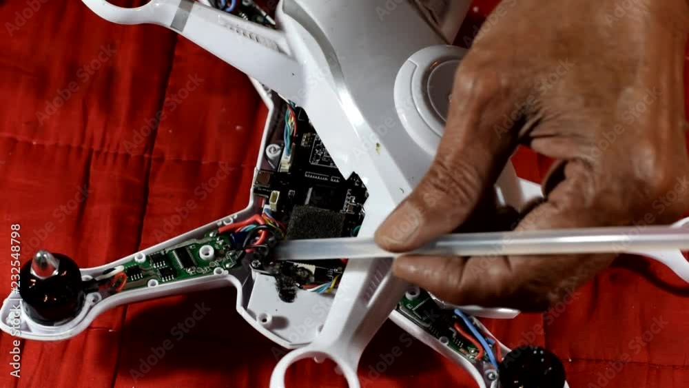 Inventive, resourceful Old man repairing broken quad-copter that he accidentally crash