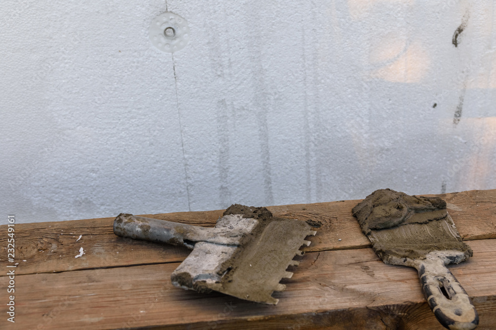 Two spatulas with mortar on old wooden board Two spatulas with mortar on old wooden board