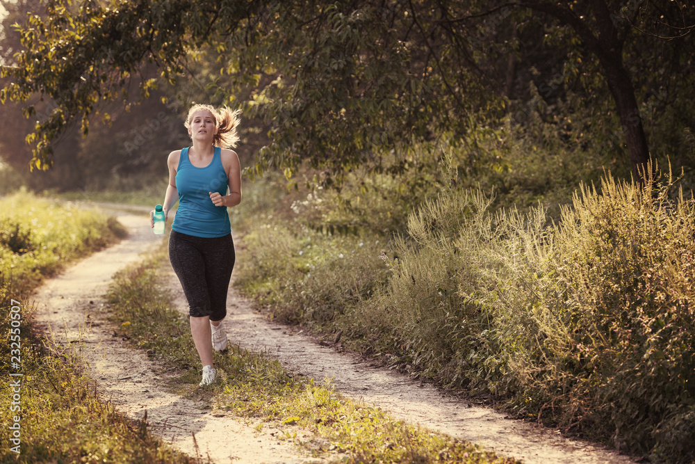 woman jogging along a country road woman jogging along a country road