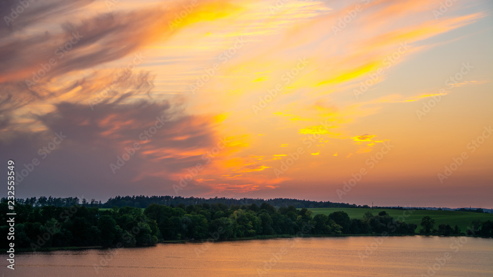 Obraz premium sunset over green field