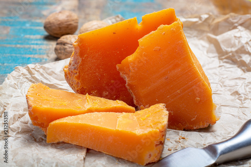 Pieces of native French aged cheese Mimolette, produced in Lille with greyish curst made by special cheese mites
