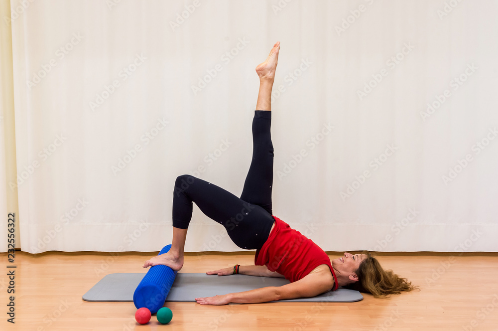 Senior woman using a foam roller in gym Senior woman using a foam roller in gym