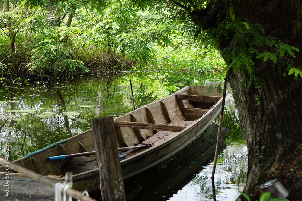 Old wooden boat floating in a canal.