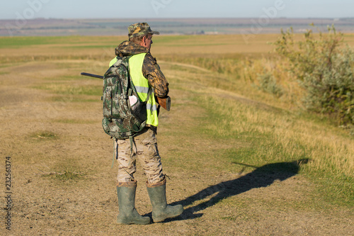 Hunter with a german drathaar and spaniel, pigeon hunting with dogs in reflective vests 