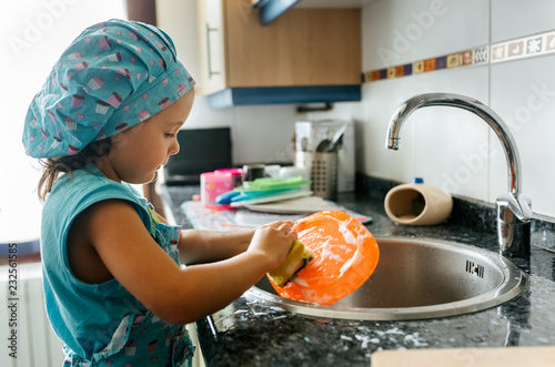Little girl washing dishes
