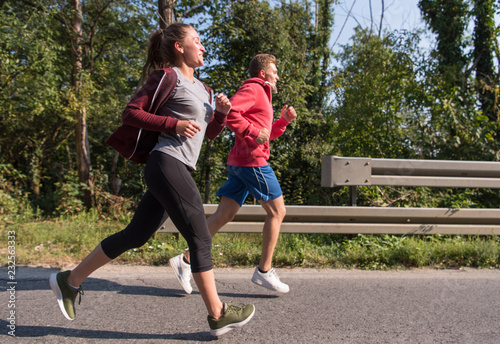 young couple jogging along a country road