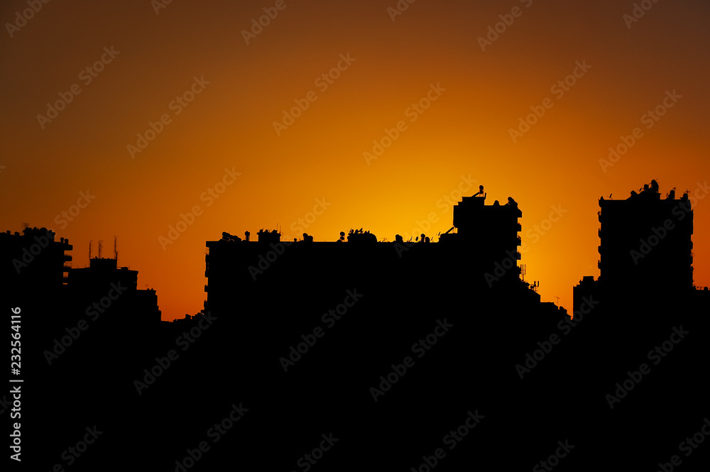 silhouette city and building skyline in front of sunset.