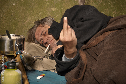 Ugly pauper man living outdoor sleeping, relaxing and laying alone on hidden urban place