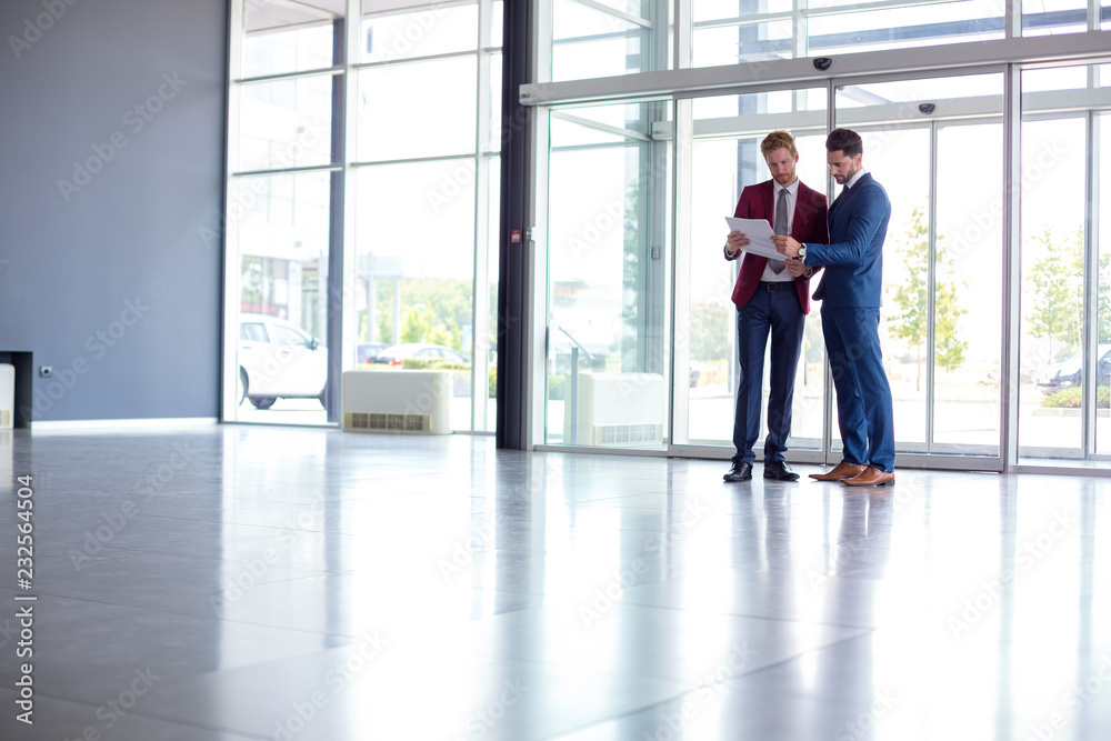 businessmen studying papers at hall