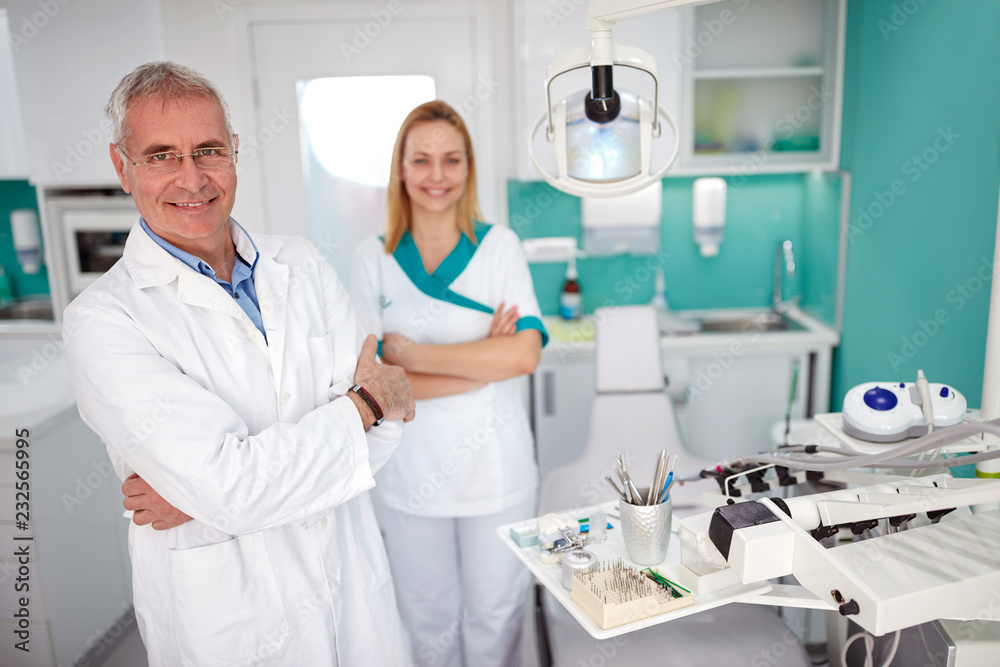 Portrait of dentist with female assistant in dental practice Portrait of dentist with female assistant in dental practice