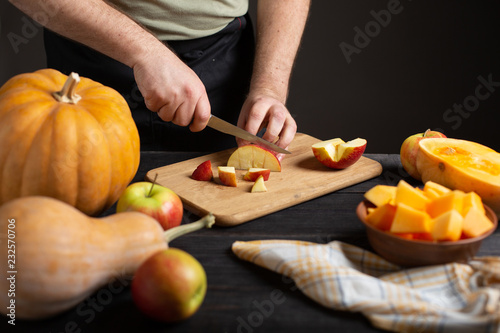 The cook cuts the apple into pieces for baking.