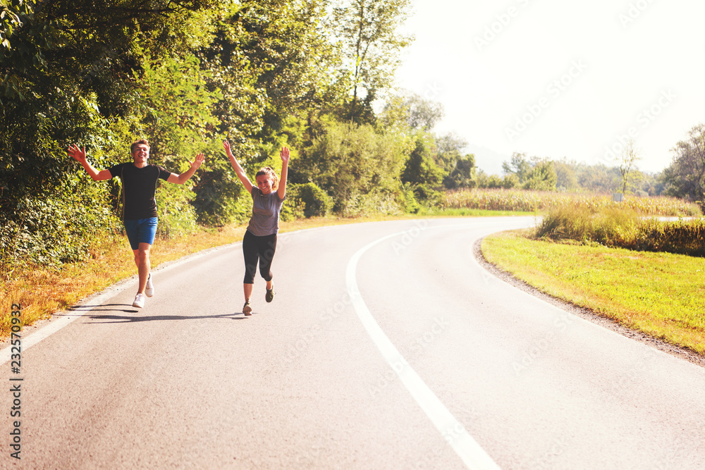 young couple jogging along a country road young couple jogging along a country road