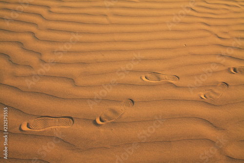 Foot ware print on the sand of a desert photo