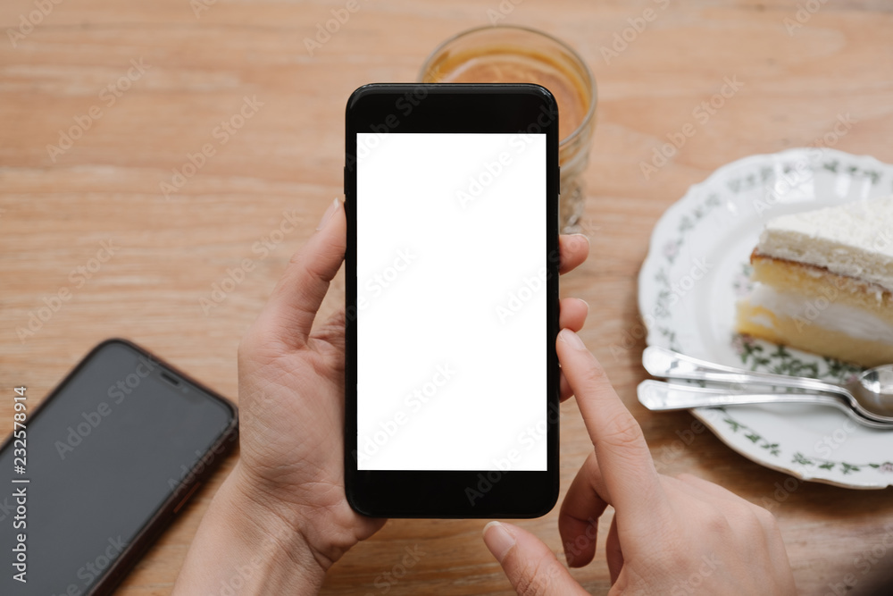 close-up on hand holding phone showing white screen on desk at coffee shop. close-up on hand holding phone showing white screen on desk at coffee shop.